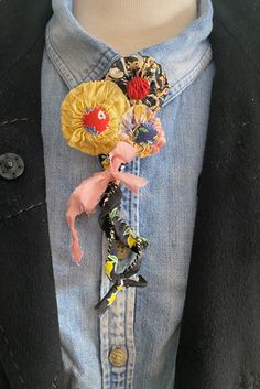 a person wearing a blue jean jacket with an animal brooch attached to it's lapel