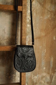 Unleash your inner fashionista with the Que Chula Chiquita Purse in stunning black! Crafted from top-quality tooled leather, this purse features a convenient front flap with a magnetic closure, as well as a detachable crossbody strap for versatile styling. Inside, you'll find a spacious interior pocket for all your essentials. Elevate any outfit with this must-have accessory! 8.5" (Height) x 3" (Depth) x 6.5" (Width) Beautiful tooled leather Scroll floral tooling on front and back of handbag Magnetic closure at top Cross-body style with adjustable leather strap Inner pocket Silver hardware Made in Mexico Black Hand Tooled Bags For Everyday Use, Black Hand Tooled Rectangular Shoulder Bag, Black Hand Tooled Shoulder Bag For Everyday, Black Leather Wallet With Adjustable Strap, Combat Boots Heels, Felt Cowboy Hats, Straw Cowboy Hat, Concert Fashion, Boot Jewelry