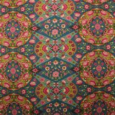 an old rug with many different colors and designs on the carpet, including pink, green,