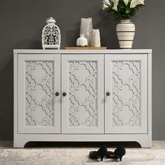 a white cabinet with two doors and flowers on top