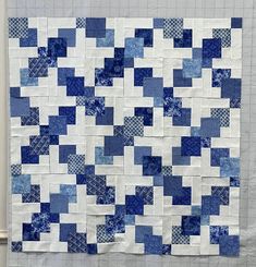 a blue and white quilt hanging on the wall