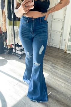 A pair of exaggerated, high-rise flare jeans featuring a front whiskered wash, open distressed knee detail, classic 5-pocket construction, frayed raw hem, and a zip-fly closure.-Rise: 11" Inseam: 33"-True to size Made In: Imported Fabric Contents: 60% Cotton, 32% Modal, 7% T400, 1% Lycra Trendy Dark Wash Flares With Frayed Hem, Denim Flare Jeans With Frayed Hem For Fall, Trendy Fall Flare Jeans With Frayed Hem, Chic Medium Wash Flare Jeans With Frayed Hem, Dark Wash Denim Flare Jeans With Frayed Hem, Distressed Wide Leg Flares For Fall, Distressed Wide-leg Flares For Fall, Ripped Cutoff Flare Jeans In Medium Wash, Chic High Rise Flare Jeans With Frayed Hem