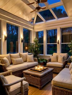 a living room filled with lots of furniture next to a window covered in plants and candles