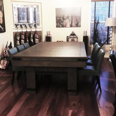 a large wooden table surrounded by blue chairs in a room with pictures on the wall