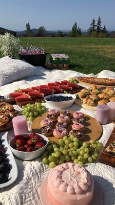 a table filled with lots of food on top of a field