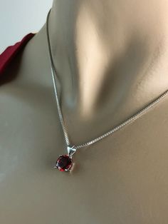 "Sterling Silver Garnet Necklace, Garnet Cubic Zirconia Pendant Necklace NECKLACE FEATURES: Metal: All components are made from solid .925 Sterling Silver Model is wearing 16\" in length solid .925 Sterling Silver Chain Length available: 16\", 18\" or 20\" Stone: Garnet CZ THE Garnet CZ pendant measures 8mm in height Your Garnet Necklace will arrive in a gift box, beautifully wrapped and ready for gifting Please send me a convo if you have any questions before placing your order. Please also vie Classic Birthday Jewelry With Prong Setting, Elegant Red Necklace For Birthday Gift, Red Necklace With Prong Setting As Gift, Red Round Stone Necklaces For Anniversary, Classic Red Birthstone Necklace As Gift, Classic Red Birthstone Necklace For Gift, Red Round Cut Necklace For Anniversary, Elegant Red Jewelry For Birthday Gift, Elegant Red Jewelry For Birthday