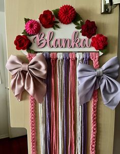 a door decorated with pink, purple and red ribbons and bows that spell out the name blanka