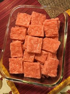 a glass dish filled with cubes of food on top of a red table cloth