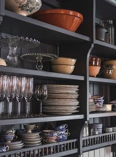 the shelves are filled with dishes and glasses