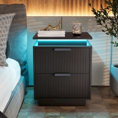 a night stand next to a bed in a room with blue walls and flooring