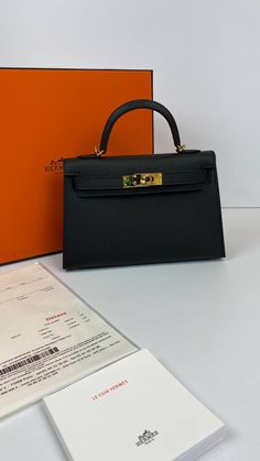 A sophisticated black Epsom leather Hermes Kelly bag with coveted gold hardware.Comes with Hermes signature orange box, shoulder strap and sleeper.d Hermes Kelly 20 Mini bag in classic black.NEW or NOT WEARABLEThe price of the Hermes Kelly 20cm retains its value due to the high demand for this limited style.Last Sale BAG MEASURES:LENGTH 20cm / 8 7/8"TALL 12cm / 4 3/4"DEEP 6cm / 2 3/8" Hermes Kelly Bag Aesthetic, Small Hermes Bag, Black Kelly Bag, Kelly 20 Hermes, Black Mini Kelly, Hermes Mini Bag, Mini Kelly Hermes, Hermes Bags Kelly, Hermes Kelly Black