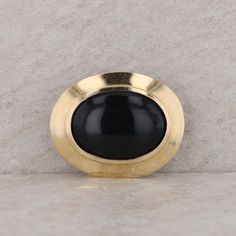 This ladies 14k yellow gold oval pendant has a bezel set cabochon onyx at the center. The onyx measures 20x15mm. The pendant measures 27.5mm in length and 20.5mm in height. The hidden bail can slide on a chain up to 6.5mm in width. The pendant weighs 6.3 grams. Condition: Pre-Owned *All items are thoroughly inspected for quality assurance purposes Luxury Engraved Oval Cabochon Jewelry, Bezel Set Cabochon, Slide On, Oval Pendant, Quality Assurance, Bezel Setting, Pendant Necklaces, Onyx, Jewelry Necklace Pendant