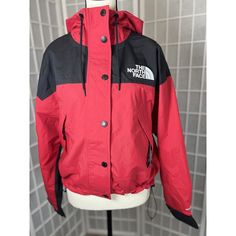 This Colorful Waterproof Jacket From The North Face Is Perfect For Travelers And Casual Wearers Alike. The Red And Black Colorblock Pattern And Parka Style Give It A Trendy Look, While The Lightweight And Wind-Resistant Fabric Make It Practical For Any Weather. The Jacket Features A Full Zip Closure, Hood, And Pockets For Added Convenience. Made With Nylon Shell Material And A Polyester Lining, This Jacket Is Both Durable And Comfortable. The Reign On Model Is Designed To Fit Regular Sizes And F Red Windbreaker With Detachable Hood For Fall, Red Waterproof Nylon Outerwear, Red Outdoor Outerwear With Detachable Hood, Fall Red Windbreaker With Detachable Hood, Sporty Red Outerwear With Detachable Hood, Functional Red Windproof Windbreaker, Red Nylon Outerwear For Outdoor, Red Functional Waterproof Windbreaker, Functional Red Waterproof Windbreaker