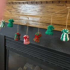 christmas ornaments are hanging on a fireplace mantel