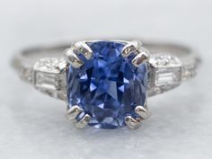 a blue sapphire and diamond ring on a white surface