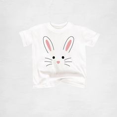 Custom handmade Bunny T-Shirt. Available in youth, toddler, and baby sizes. Perfect shirt for Easter and spring! H O W T O O R D E R Y O U R S H I R T : At checkout, please select the size you want, add to your cart, and then checkout through Etsy. If the size you want isn't in stock, I will message you right away and there will be a 2-3 day turn around time added to getting your shipment out. If you have a time deadline and want to check sizes on hand before you purchase, feel free to message m Family Matching White T-shirt With Cartoon Print, Cute White T-shirt With Bunny Design, Playful Unisex T-shirt With Character Print, Screen Print Short Sleeve T-shirt For Playtime, Cute Short Sleeve T-shirt With Custom Print, Cute Shirt With Graphic Print For Playtime, Fun Character Print T-shirt, Casual T-shirt With Custom Print For Playtime, Fun T-shirt With Character Print For Gift