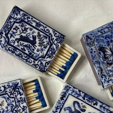 four matchboxes with blue and white designs are arranged in a square pattern on the table