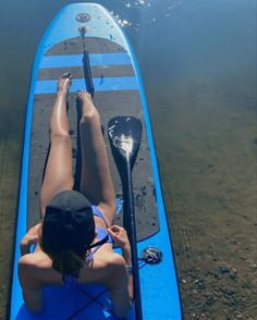 a woman laying on top of a blue kayak