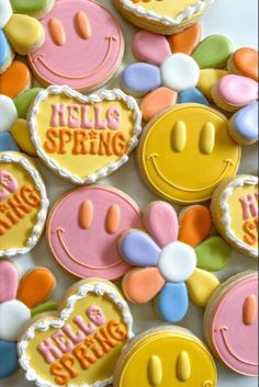 some cookies that are decorated with smiley faces and the words hello spring written on them