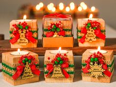 six candles with christmas decorations on them sitting in front of a lit candle holder and some lights