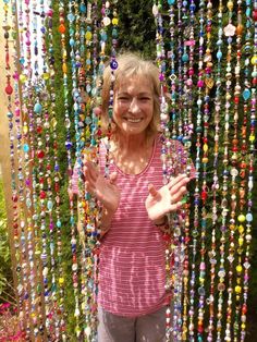 a woman standing in front of a bunch of beads