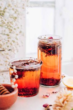 two jars filled with liquid sitting on top of a table