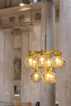 a chandelier hanging from the ceiling in a room with marble columns and pillars