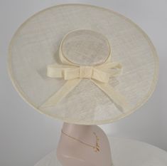 There is an elastic string with the base hat, it will help you to hold fascinator easier! Sinamay saucer hat base hat that measures approximately 18.5 inches side to side, front to back is also the same size, 18.5 inches, colors are available, black, off white, pink, hot pink and pink and lime green, it will help you to support for your millinery creations. Edges trimmed in matching grosgrain ribbon.it comes with an elastic!   💃1. All hats will be sent from Rockville, MD, 20850, using FedEx Gro Classic Cream Fitted Top Hat, Classic Adjustable Cream Boater Hat, Adjustable Beige Hat Bands For Formal Occasions, Classic Fitted Cream Boater Hat, Fitted Cream Top Hat With Flat Brim, Cream Fitted Top Hat With Flat Brim, Adjustable Beige Top Hat With Curved Brim, Elegant Adjustable Beige Hat Bands, Beige Top Hat With Adjustable Fit And Curved Brim