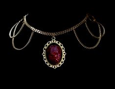 13" rhodium or 24k gold plated curb chain choker with a munified chicken heart sealed in resin on silver or gold tone cameo frame pendant. Adjustable 2" length