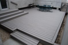 an outdoor deck with steps leading up to the dining room table and chairs on it