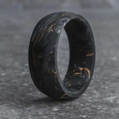 a black and gold wedding ring on concrete