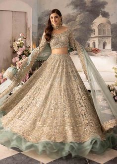 a woman in a gold and green lehenga