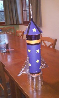 a purple rocket ship sitting on top of a wooden table