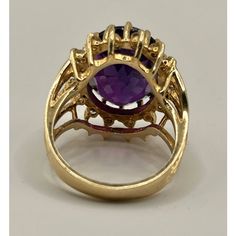 This is part of Chairish’s Fine Jewelry assortment.  14k yellow gold cocktail ring featuring a deep purple/red/blue oval amethyst, encircled by 16 small diamonds.  Ring Size: 6 in. Stone: 16.42 x 12.40 x 8.7 mm Ring Weight: 6.7 grams  If you would like more information, please contact me via email, mrboult@gmail.com. Collectible Oval Rings With Gemstone Accents, Oval Amethyst Ring With Gemstone Accents For Formal Occasions, Oval Yellow Gold Cluster Ring With Gemstone Accents, Gold Amethyst Ring With Halo Setting, Oval Amethyst Ring With Gemstone Accents, Fine Jewelry Oval Amethyst Ring In 14k Gold, Formal Oval Cluster Ring With Gemstone Accents, Purple Oval Ruby Ring, Fine Jewelry, Oval Amethyst Ring With Accent Stones In 14k Gold