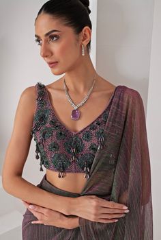 Elevate your style with the exquisite Lavender Pre Draped Crepe Saree, meticulously crafted from a luxurious platinoir crepe. The lavender saree shimmers with a subtle metallic tone, adding a touch of contemporary elegance to the traditional silhouette. Paired with a sleeveless V-neck blouse, this ensemble showcases intricate tonal crystal tassel and cutdana embellishments, creating a perfect blend of modern flair and classic grace. The pre-draped design ensures effortless wear, making it an ideal choice for those who desire both sophistication and convenience. Whether you're attending a Cocktails, Sangeet nights or a glamorous evening event, this saree promises to make a statement, reflecting your impeccable taste and style. Composition : Blouse - Crepe blend, Saree - Platinoir Crepe Care Lavender Saree, Sleeveless V Neck Blouse, Draped Saree, Crepe Saree, Drape Saree, Purple Metallic, Indian Wedding Wear, Designer Drapes, Blouse For Women