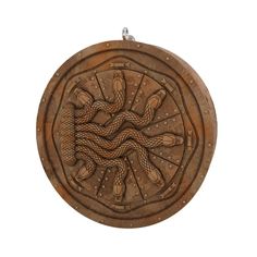 a wooden plaque with an intricate design on the front and sides, depicting two snakes