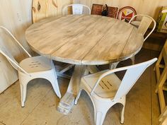 a wooden table with four white chairs around it in a room filled with other furniture