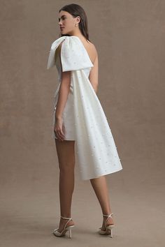 The Sachin & Babi Pippa Mini Dress is the perfect show-stopping number for every bridal occasion. This mini silhouette is made of a silky dupioni fabrication. A wrapped front and dramatic one-shoulder neckline with a bow sleeve are dotted with stunning droplets of beautiful pearls - finishing the look with a sea-inspired touch. | Pippa One-Shoulder Pearl-Embellished Mini Dress by Sachin & Babi in White, Women's, Size: 0, Polyester/Silk at Anthropologie Wedding Dress With Bow, Tight Wedding Dress, Mini Wedding Dress, Sachin Babi, Mini Wedding Dresses, Bow Wedding Dress, Beach Wedding Dress Boho, Sequin Prom Dresses, Mini Wedding