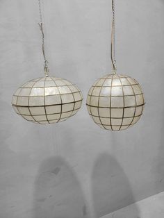 two lamps hanging from chains on a wall