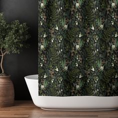 the shower curtain is decorated with green leaves and flowers