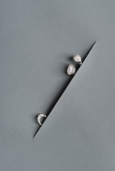 two small diamond studs sitting on top of a piece of paper