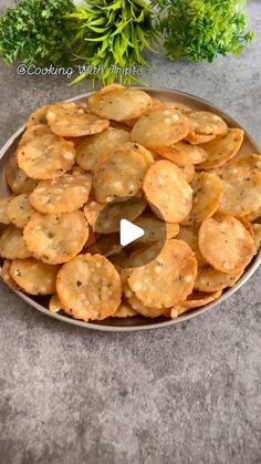 a plate full of crackers sitting on top of a table next to some parsley