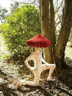 a woman with red hair is standing next to a tree