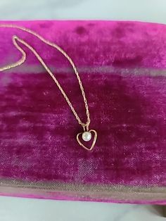 This is a vintage 14K yellow gold filled heart-shaped pendant with an accent pearl. Hallmarks: 1/20 14K PPC, 14KGF Weighs: DOES NOT REGISTER ON MY SHIPPING SCALE 19.25" long Pendant measures .5" tall with bale and 3/8" wide All measurements are approximate. Condition: Vintage condition. Normal wear associated age. Please see photos. Sold as is. Priced accordingly. Please look over carefully and inspect any and all photos. Our shop is committed to fully disclosing all items' conditions and histor Gold Heart Necklace With Pearl Charm For Valentine's Day, Gold Heart Necklace With Pearl Pendant For Valentine's Day, Dainty Gold Heart Necklace With Pearl Pendant, Valentine's Day Gold Heart Necklace With Pearl Pendant, Gold Heart Necklace With Pearl Pendant, Vintage Heart Pendant Jewelry With Pearl, Heart-shaped Yellow Gold Jewelry With Pearl Charm, Yellow Gold Heart Jewelry With Pearl Charm, Yellow Gold Heart Necklace With Pearl Charm