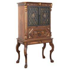 an ornate wooden cabinet with carvings on the front and sides, against a white background