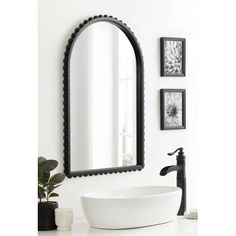 a bathroom sink sitting under a mirror next to a black faucet mounted on a wall