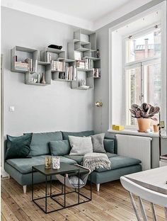 a living room filled with furniture and bookshelves on the wall next to a window