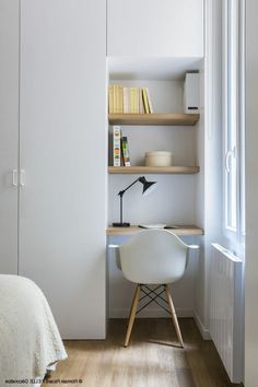 a bedroom with a bed, desk and book shelf in the corner next to it