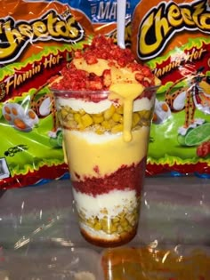 there is a dessert in the cup with candy on top and other snacks behind it