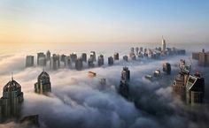 an aerial view of skyscrapers above the clouds